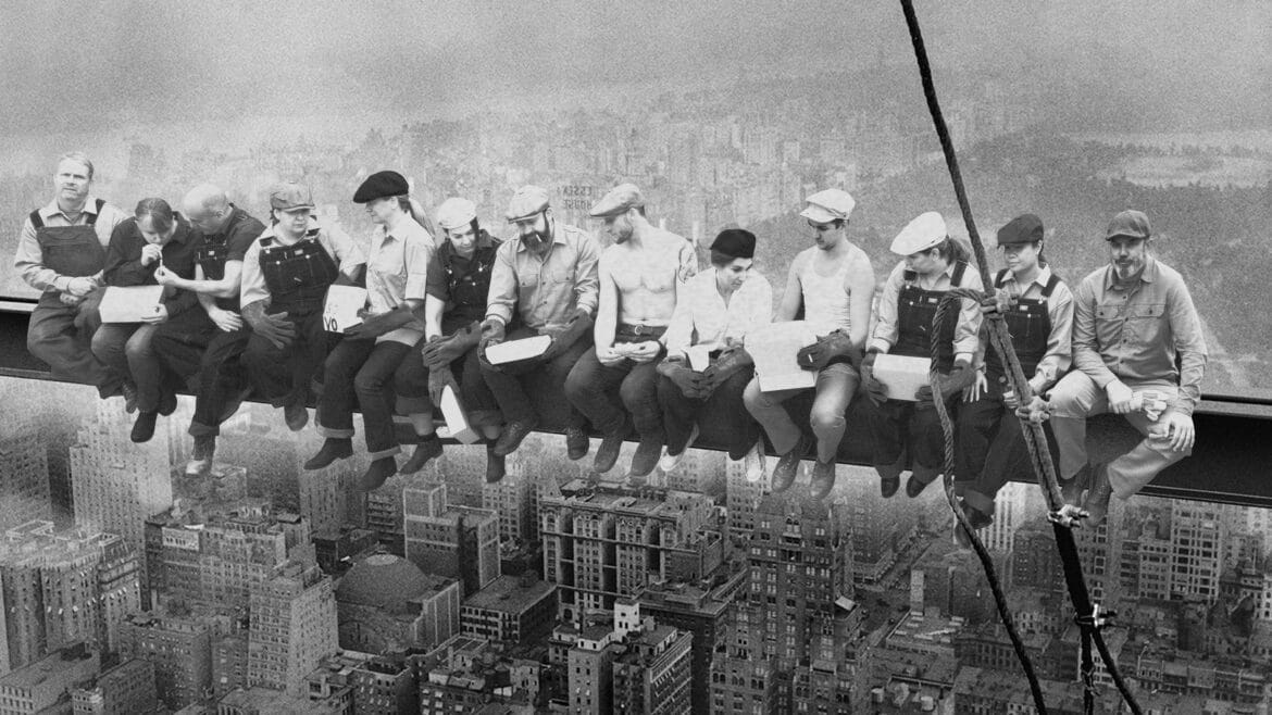 Architect and builder team in costume emulating the black and white lunch atop a skyscraper photo from 1932