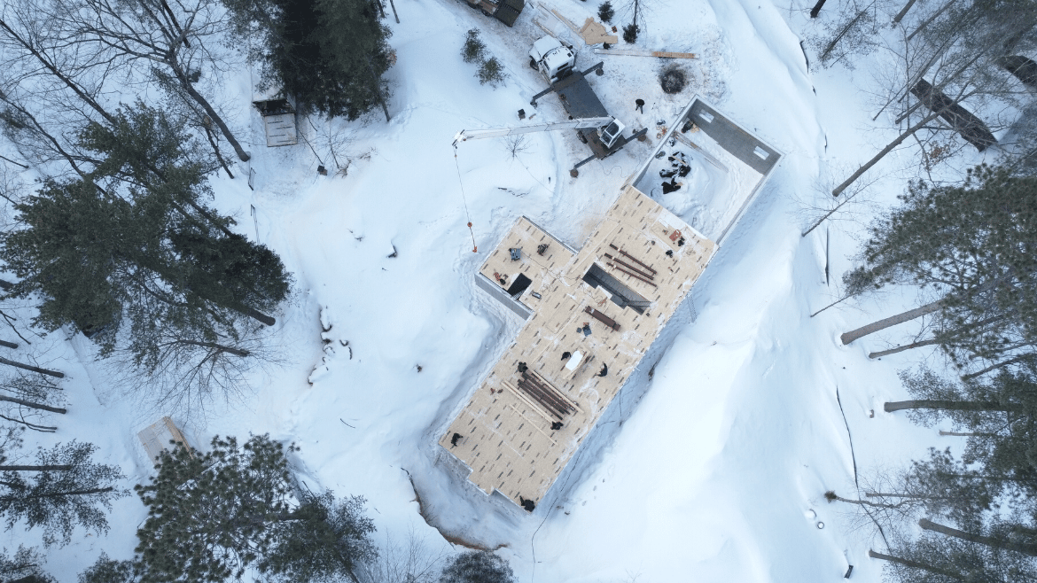 Drone shot of new home construction in winter, floor over basement foundation