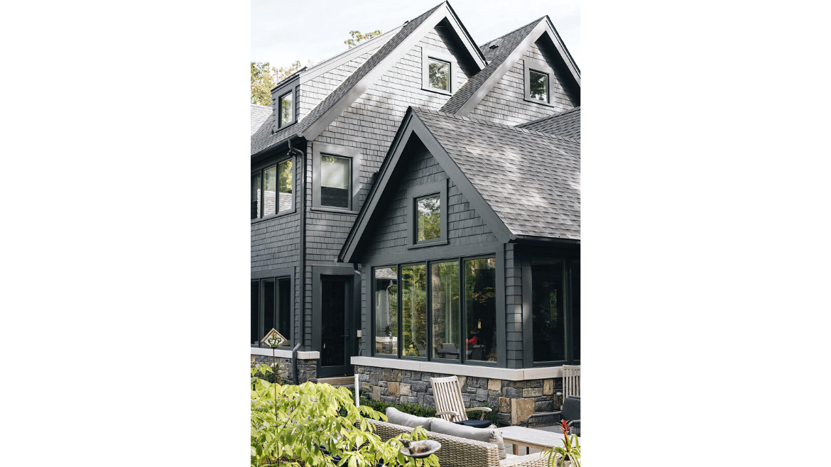 Modern mountain craftsman style home family room exterior with dark, monochromatic color scheme and multiple bump outs