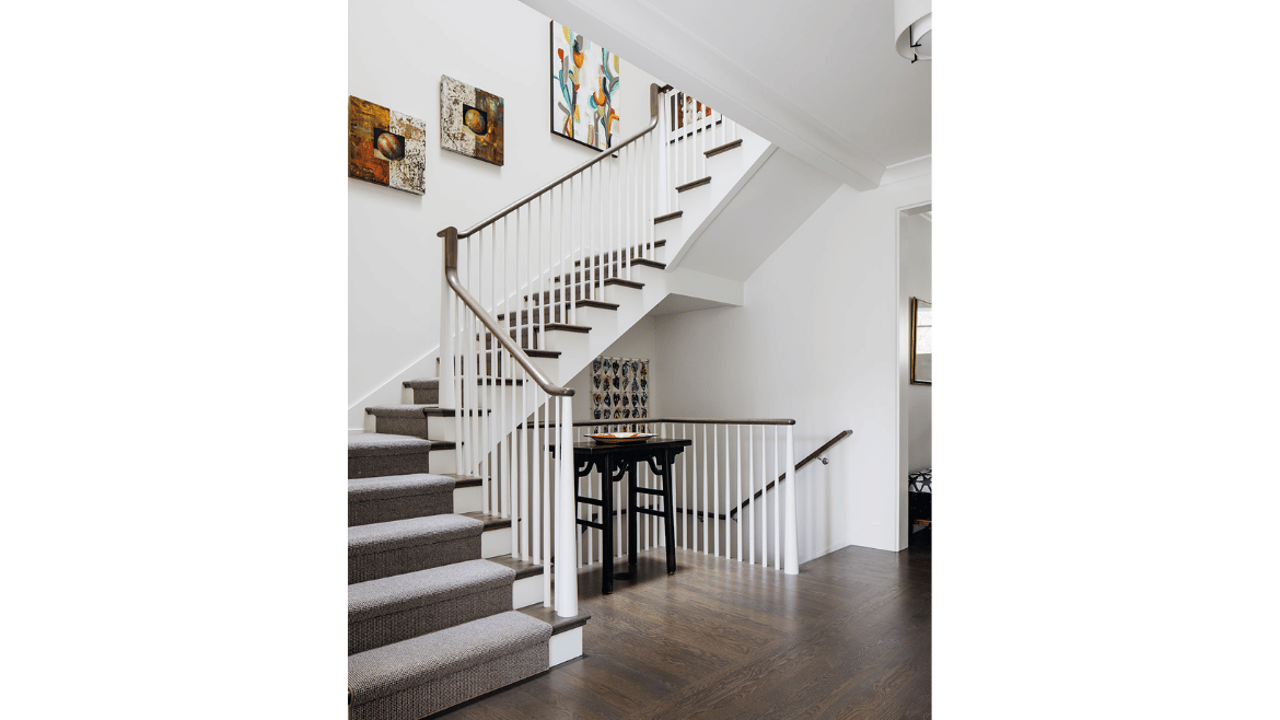 Modern mountain craftsman home foyer of white banister stairs with dark treads