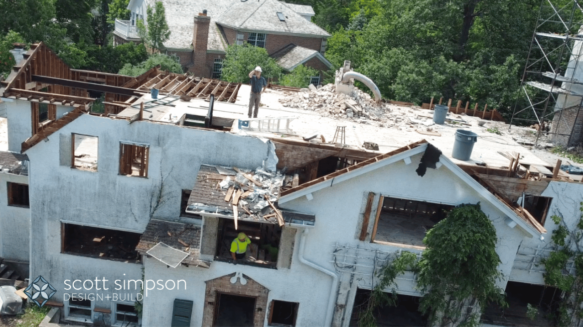 Drone shot of builder on top of house during deconstruction phase in Winnetka, rubble and exposed bricks and beams