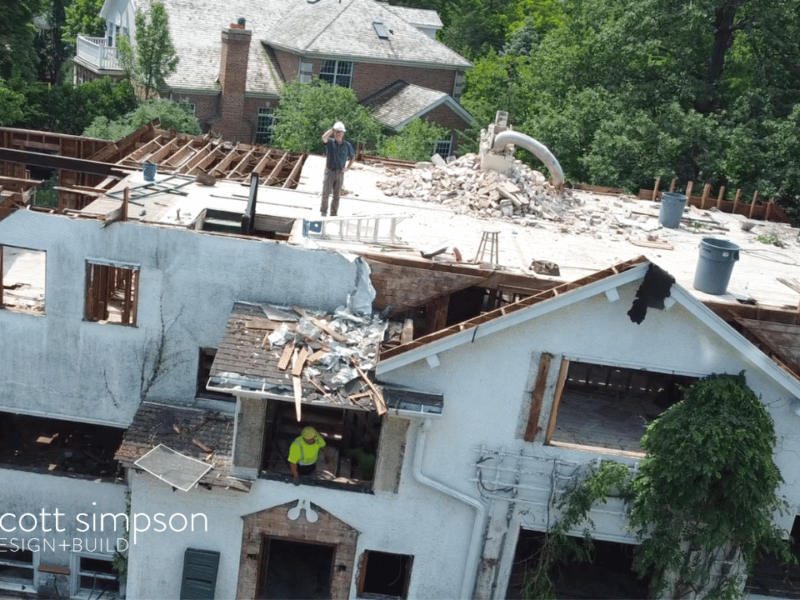 Drone shot of builder on top of house during deconstruction phase in Winnetka, rubble and exposed bricks and beams