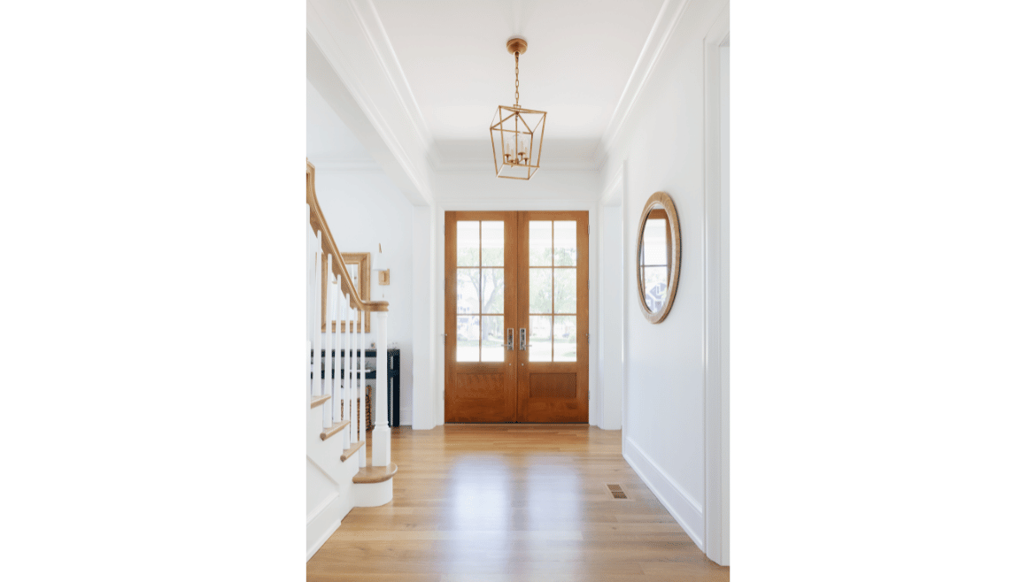 All white front foyer farmhouse design with natural wood double front doors, railing, floors and stairs