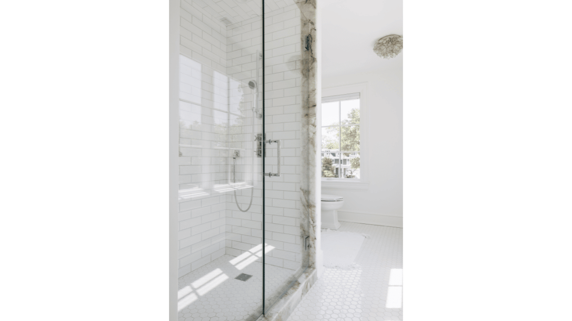 Stand-up glass shower with white subway tiles and specialty marble trim