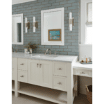 Farmhouse double sink vanity with furniture quality white cabinetry and countertops accented by gray green subway tiles and sconces