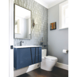 Powder room with floating navy blue vanity and full gray tiled walls