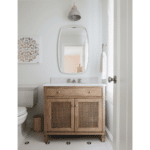 Rattan cabinet powder room vanity with single sink, overhead light, rounded mirror and flower tile design