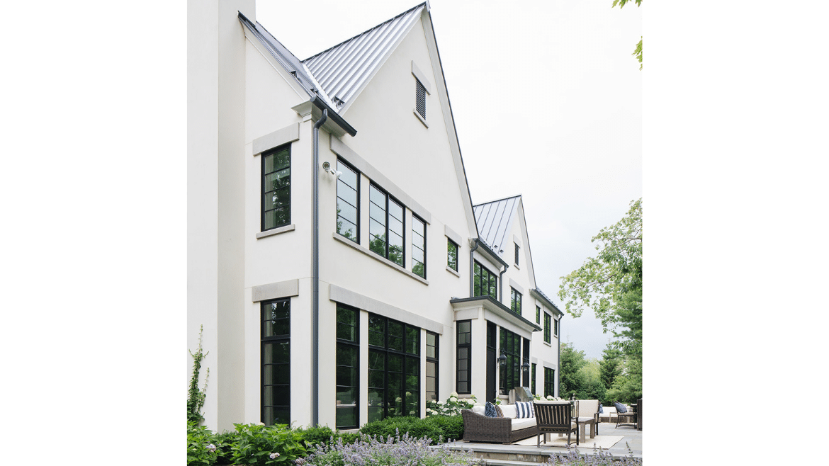 Modern Tudor home back patio - white exterior with black windows and modern horizontal mullions
