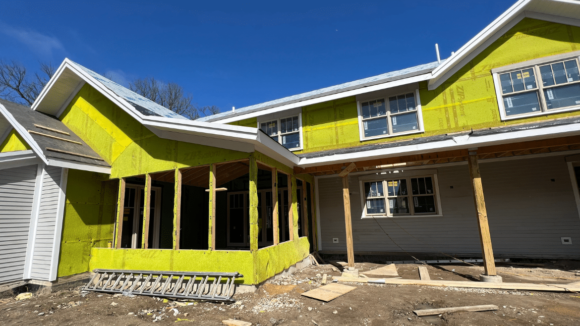 New construction home in process with yellow/green slicker rainscreen product on the exterior